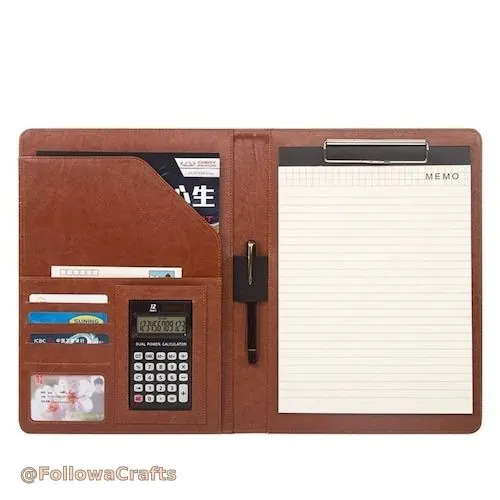 Black leather padfolio open with silver calculator and notepad