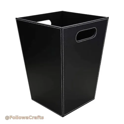 Round dark brown leather waste bin in office