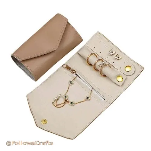 Open PU leather travel jewelry roll showing multiple pockets and rings
